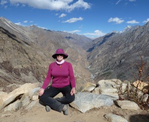 Photograph of Phillipa Wilson, Yoga Teacher sigging on a rock in a crossed leg pose