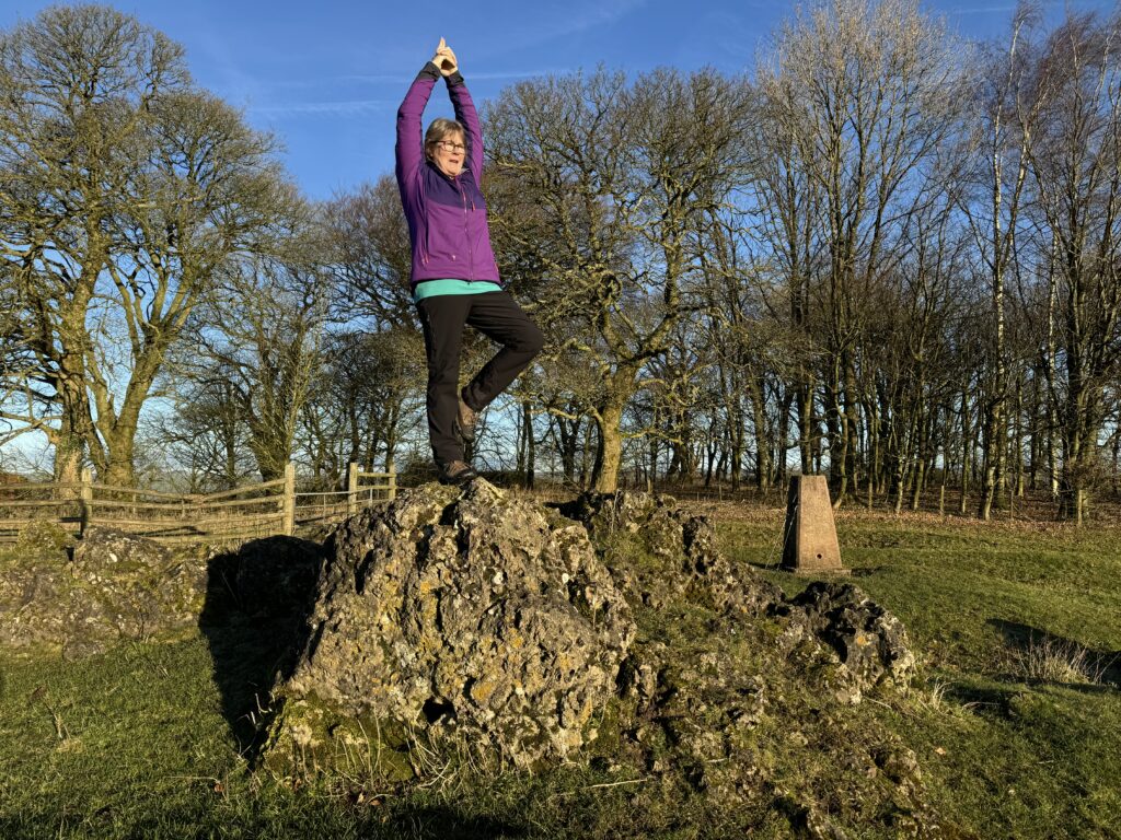 Photograph of Phillipa Wilson, Yoga Teacher sigging on a rock in a crossed leg pose
